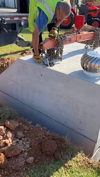 Worker securing storm shelter lid with chains in Lubbock TX