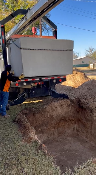 Crane lifting shelter over excavation in Roaring Springs TX