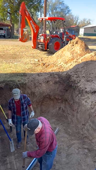 Workers preparing gravel base in excavation in Roaring Springs TX