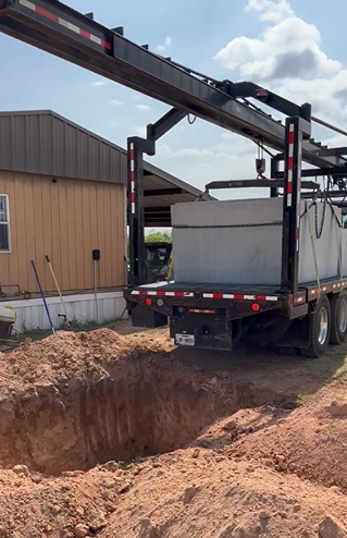 Storm shelter on flatbed truck arriving at job site in Roaring Springs TX