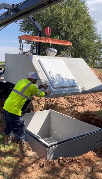 Crane lowering lid onto storm shelter in Spur TX