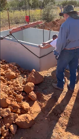 Workers positioning concrete storm shelter in Spur TX